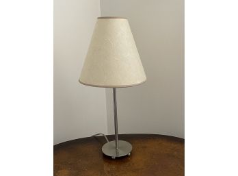 A Chrome Table Lamp With A Textured Shade