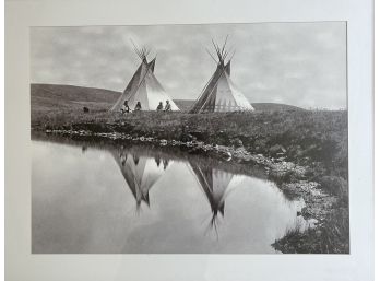 A Black And White Photograph Of Teepee Along A River - Framed And Matted