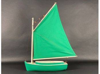 A Simple Wooden Sailboat Model In Green