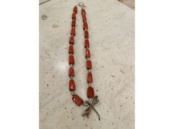 A Silver Dragon Fly Pendant Necklace With Red Stone Beads