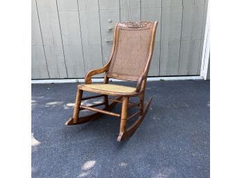 An Oak Rocker With Caned Seat And Back And Eagle Carving