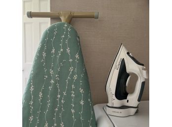 A Rowenta Iron With Cord Reel And Ironing Board
