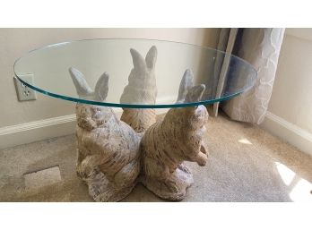 A Glass Top Coffee Table With Plaster Bunnies Base