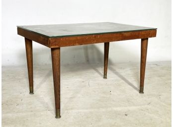 A Mid Century Modern Wood Coffee Table With Glass Top