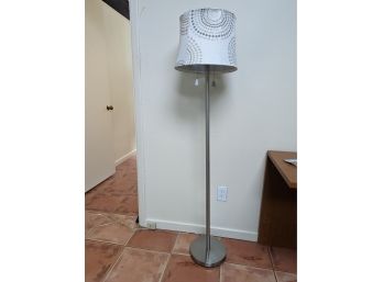 A Free Standing Floor Lamp In Brushed Chrome With Modern Shade