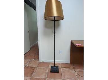 A Metal Floor Lamp In Bronze Tone And Metalic Shade