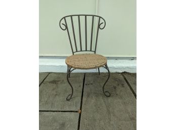 A Metal Garden Chair With Woven Rattan Seat
