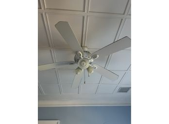 A Ceiling Fan With Lights And Control Switch