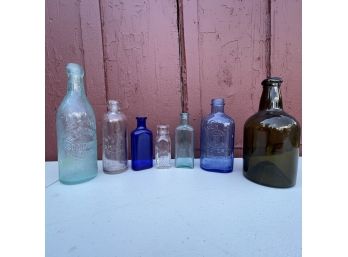A Set Of Antique Collectible Glass Bottles In Various Colors