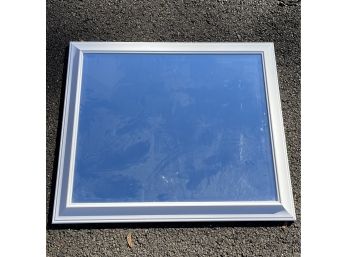 A Beveled Mirror In A White Composite Frame - 25 X 29