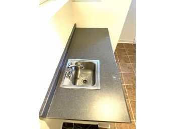 A Laminate Countertop With Metal Sink