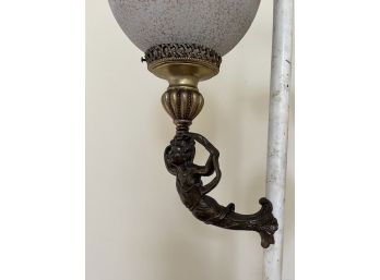 A Light Pole With Base And 2 Brass Cherub Figurines With Decorative Globe