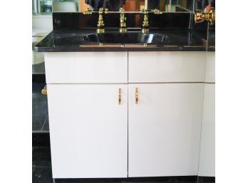 A Black Composite Top Vanity With Gold Tone Hardware - Bath 1