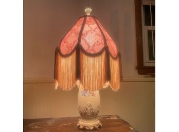 White Table Lamp With Flowers And Pink Shade With Fringe And Lace Detailing