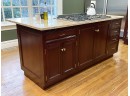 A Mahogany Kitchen Island With Granite Counters And Themador Gas Range - Counter