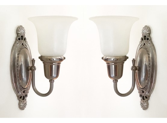 A Pair Of Chrome Sconces With Frosted Glass Shades