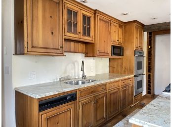 Solid Paneled Pine Kitchen Cabinets And Granite Counters With Stainless Sink, Dishwasher, And Microwave
