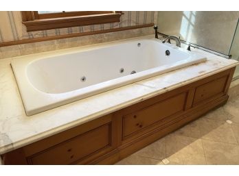A Paneled Pine Jacuzzi Tub With Luxe Bath Fittings And Marble Surround