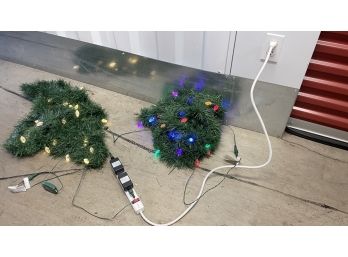 A Pair Of Christmas Lights And Greenery With Attached Remote For Changing Colors