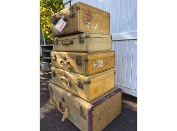 A Collection Of Vintage Leather Suitcases With Travel Stickers