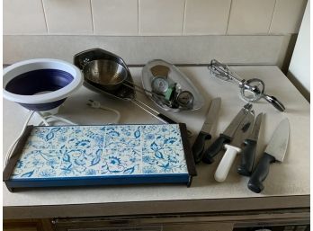 Kitchen Items: Plate Warmer, (1)sm.metal Tray (5) Knives (3) Colanders (1) Egg Beater  (2) Thermometer