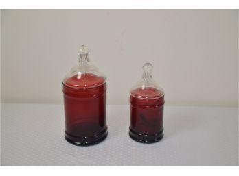 (#68) Red Glass Canisters With Clear Glass Covers 7' And 9'H