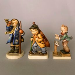 Three Hummel Figurines: Conductor, Boy With Horn, #129 Band Leader W/Music Stand And Little Cellist # 89