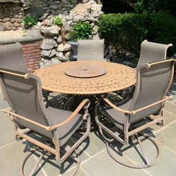 Cast Aluminum Round Outdoor Table With 5 Royal Sling Swivel-Rocker Arm Chairs Both In Cinnamon Finish By Beka