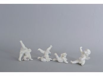 Set Of Four Porcelain Tumbling Angel Figurines
