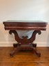 American Empire Period Flame Mahogany Flip Top Console Table - Original Brass Casters, Tulip Shaped Base