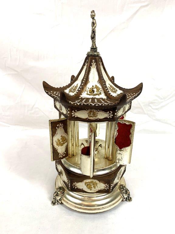 Sold at Auction: Vintage musical carousel lipstick/cigarette holder, with  warriors and maidens on porcelain panelled doors and chariots on roof,  topped by metal cherub. Hand painted. On tri-footed metal base. Approx 34cm