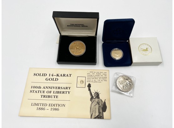 (114) LOT OF 4 COINS/MEDALLIONS-14KT GOLD STATUE OF LIBERTY, 1987 CANADIEN DOLLAR, BICEN. MEDAL & ELIZABETH 11