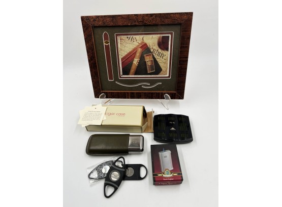 (104) LOT OF 7 CIGAR  ITEMS- CIGAR CASE, 3 CIGAR CUTTERS, 1 TORCH LIGHTER, 1 USED HUMIDIFIER & FRAMED PHOTO