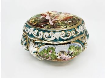 (L-31) VINTAGE CAPODIMONTE, ITALY  LIDDED PORCELAIN BOX DECORATED WITH CHERUBS -SEE CHIP TO EDGE  -9' BY 5'