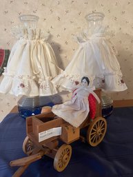 Pair Of Oil Lamps And Porcelain Doll On Wood Wagon