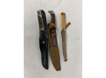 Three Knives With Sleeves Including One By Buck