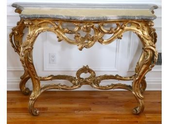 Exquisite Gilded Chavignol Rococco Console With A Thick Grey Marble Stone Top That Has A Beveled Ogee Edge
