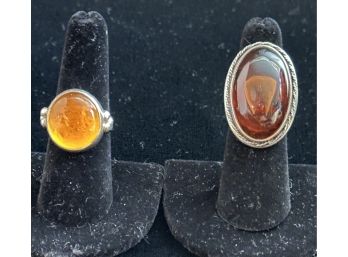 PAIR OF STERLING SILVER AND AMBER RINGS - OVAL RING SIZE 6.25, ROUND RING SIZE 7.75