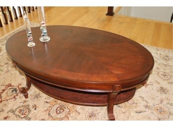Brown Mahogany Oval Coffee Table With Bottom Shelf And Decorative Glass Thermometers