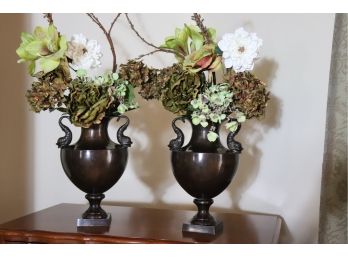 PAIR OF DECORATIVE METAL OIL RUBBED BRONZE FINISHED URNS WITH DOLPHIN/SERPENTINE HANDLES & FLORAL DISPLAY