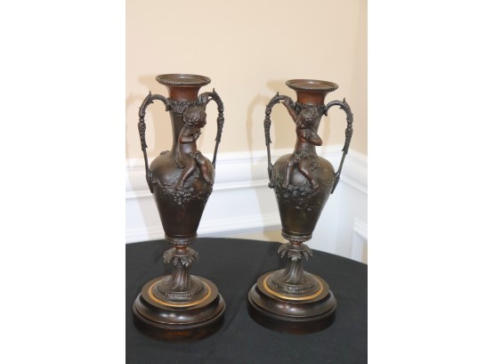 Pair Of Ornate Cherub Adorned Metal Urns With Heavy Brass Base