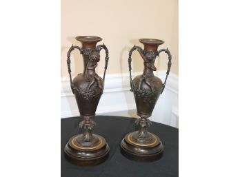 Pair Of Ornate Cherub Adorned Metal Urns With Heavy Brass Base