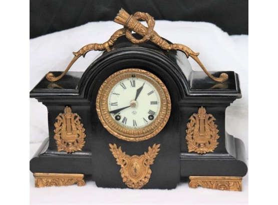 Ansonia Metal Mantle Clock With A Bronze Colored Finish, Torch/Wreath Detail & Porcelain Face