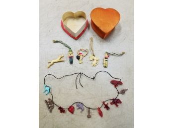 Collection Of Antique C.1940s Miniature Plastic Charms On Strings In Silk Heart Box, Animals People Military