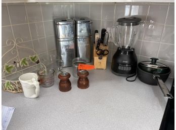 Kitchen Lot: (1) Flour, Sugar, Tea & Coffee Canister Set (2) Liquid Measuring Cups (1) Salt & Pepper (1) Oster Blender (2) Pots (1) Flour Sifter (1) Wall Hanging Basket