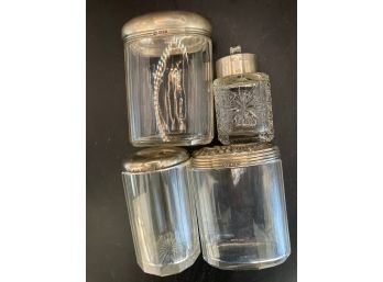 Four Glass Jars With Silver Lids