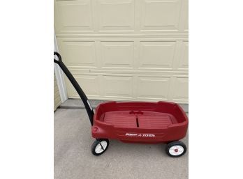 RED PLASTIC RADIO FLYER WAGON WITH FOLDING SEATS AND STRAPS