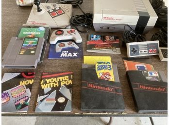 Vintage Nintendo Video Game System With A Collection Of Games And Additional Controllers