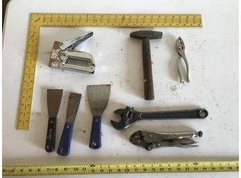 Assortment Of Tools Featuring Yellow Square, Staple Gun, Vice Grips, Pliers, Putting Knives, Wrench, & Hammer