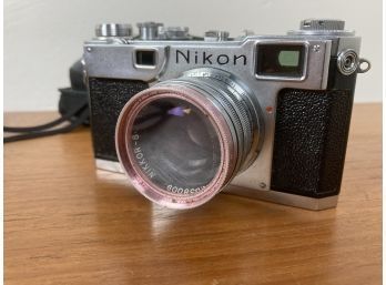 Two Vintage Cameras Featuring A Vintage Nikon And A Rollei XF 35